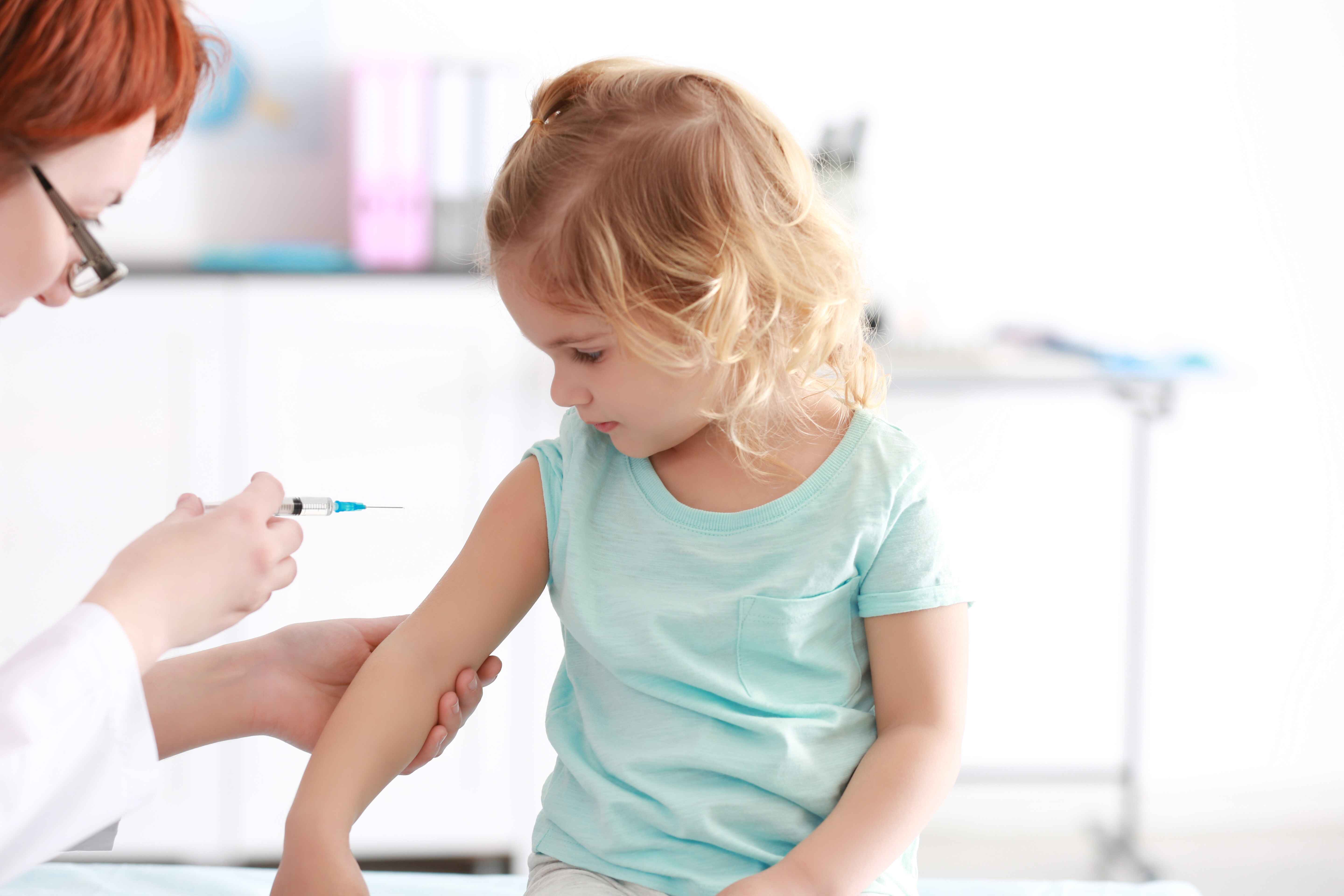 Young girl receiving a vaccination in a medical office.