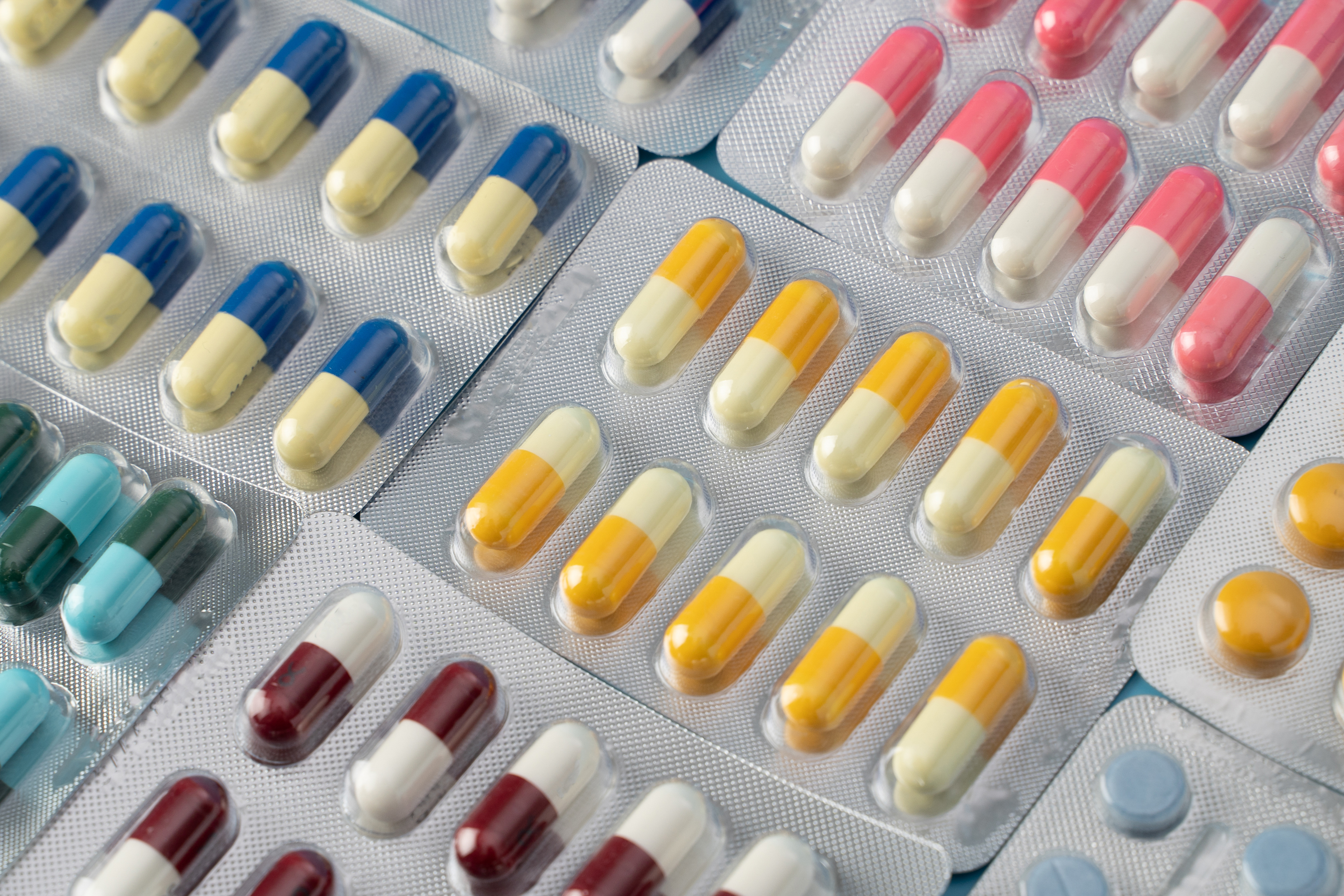 Assorted packs of colorful capsules and tablets.