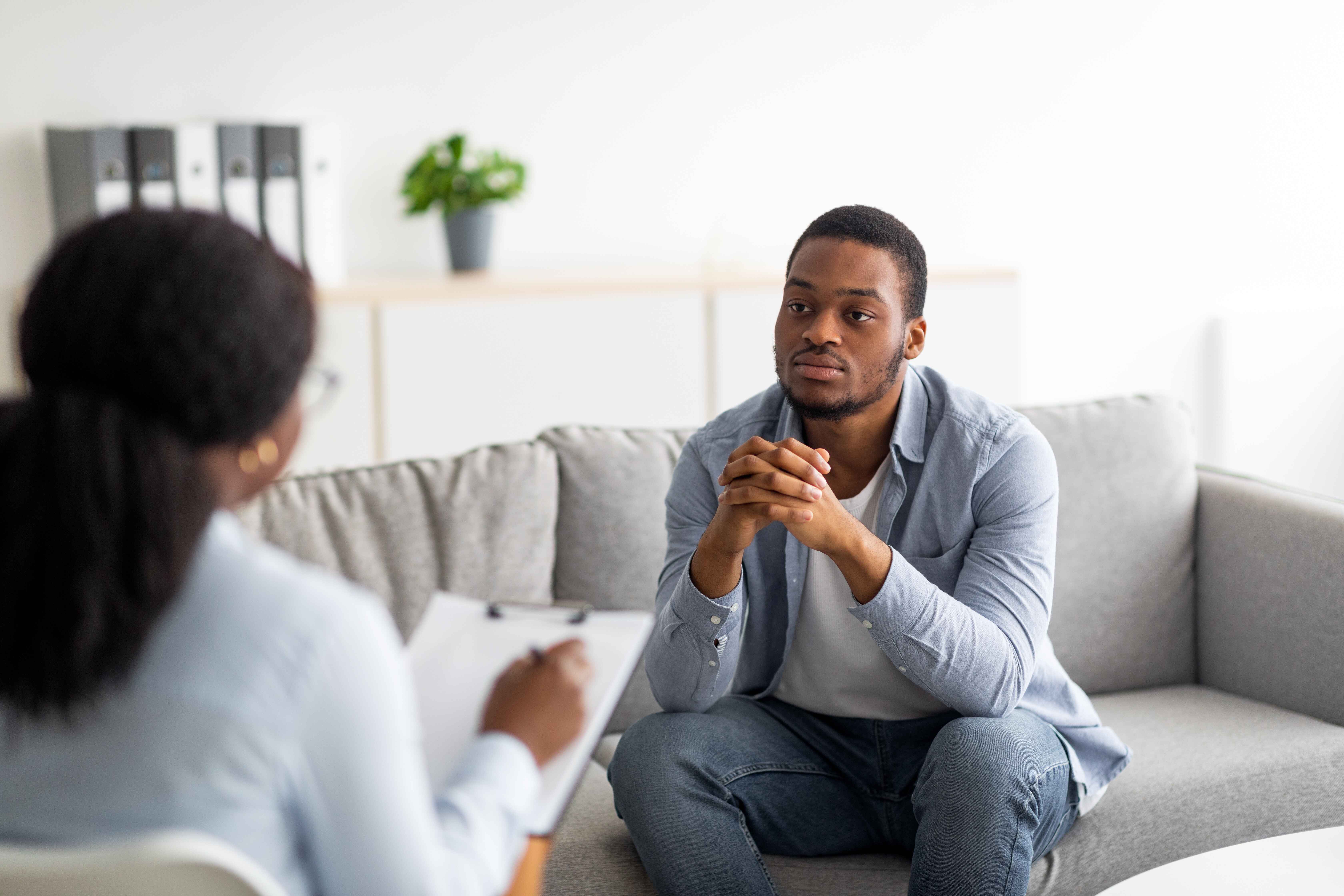 A man in casual attire engaged in conversation during a counseling session.